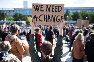 Protester holding sign that reads, "we need a change".