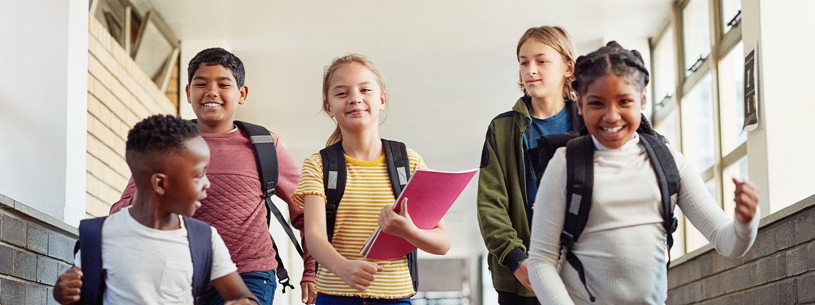 Kids of different ages walking down a school hallway