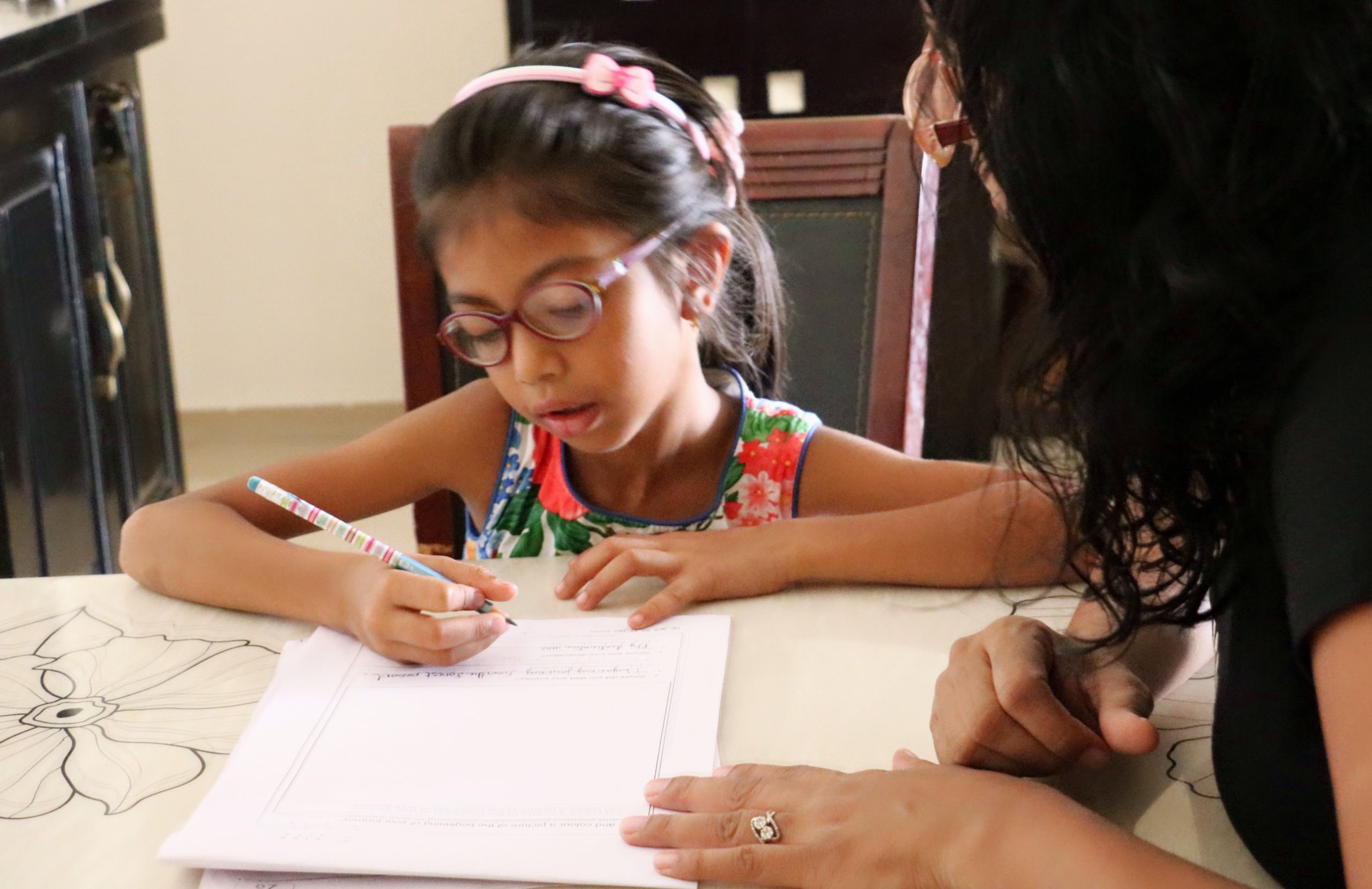 Mother helping her daughter with homework.