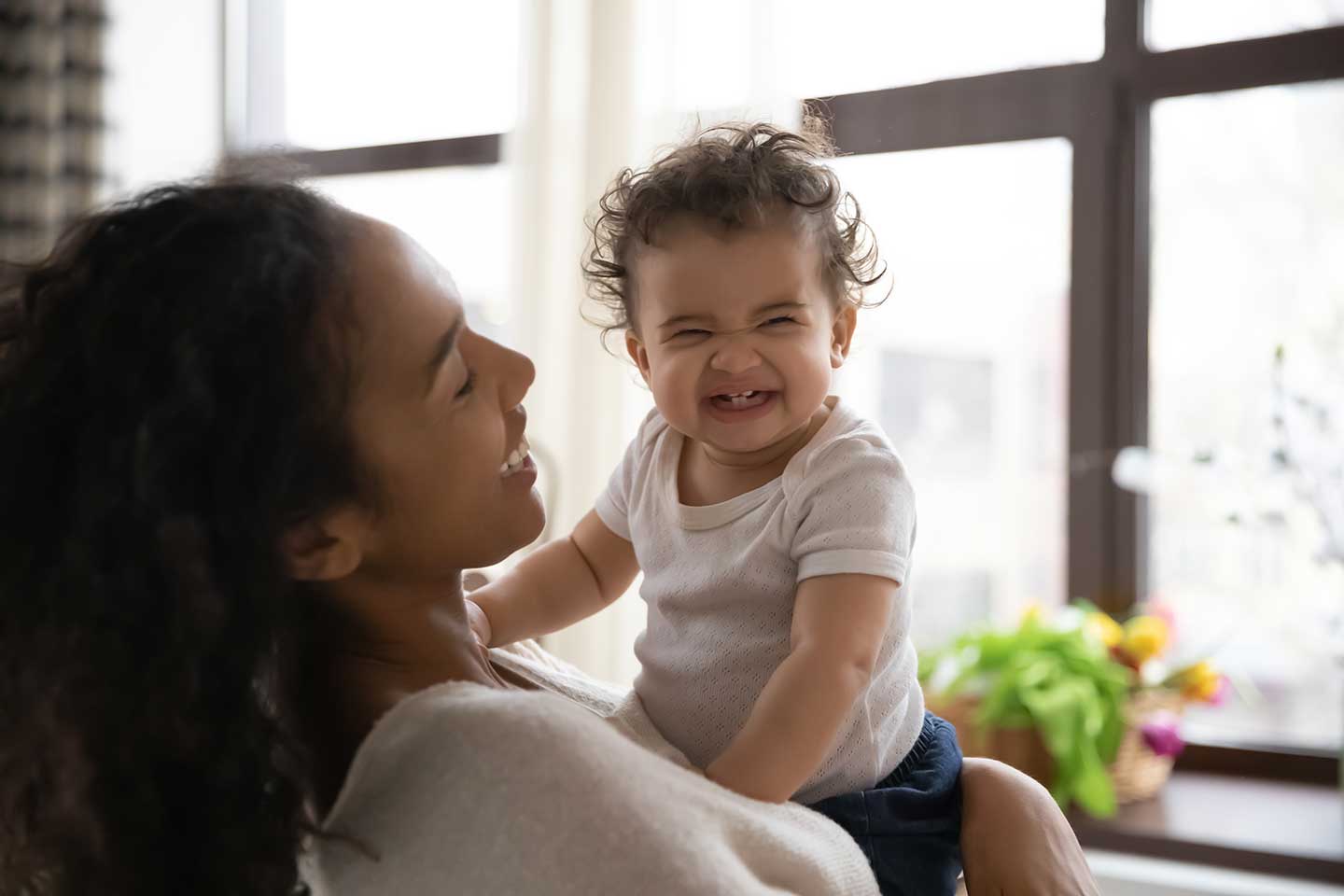 Mom holding smiling baby.